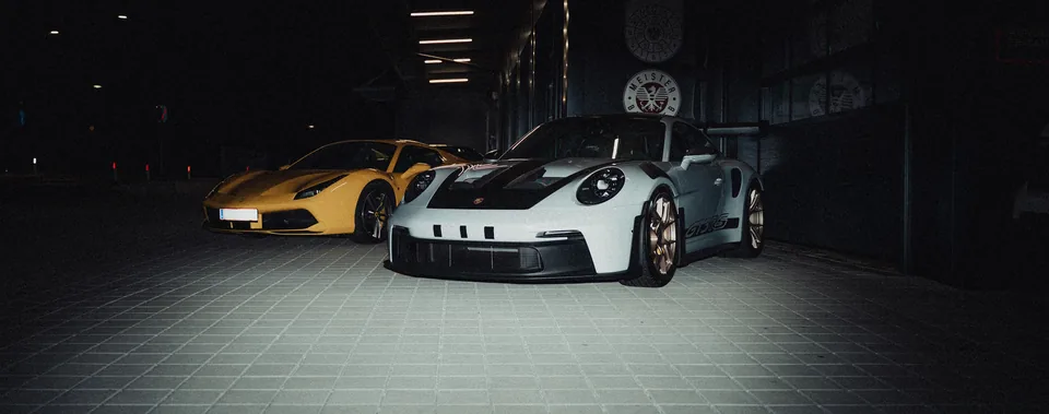 Porsche und Lamborghini in einer dunklen Garage
