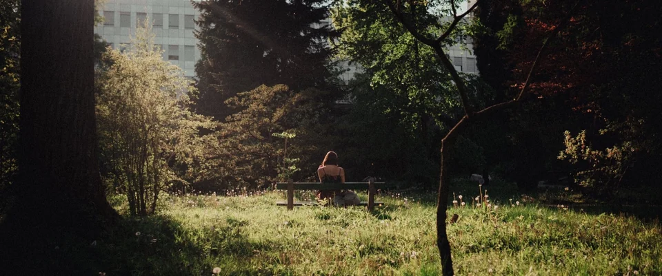 Person auf einer Bank in einem sonnenbeschienenen Park in Zagreb
